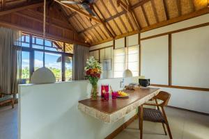a kitchen with a table with a vase of flowers on it at Incense Impossible Beach Boutique Hotel - Adults Only in Uluwatu
