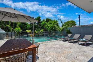 a patio with a table and chairs and a swimming pool at Stonecutters 2 in Byron Bay