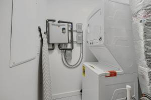 a bathroom with a washer and dryer next to a washer at Ember & Oak - Modern Retreat Near Downtown - Pets in St. Augustine +37 photos