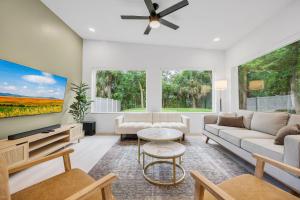 a living room with white furniture and a large window at Ember & Oak - Modern Retreat Near Downtown - Pets in St. Augustine