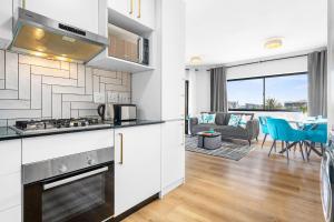 a kitchen and living room with a couch and a table at Cape on Popham 21B in Bloubergstrand