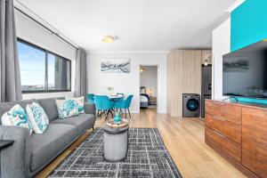 a living room with a couch and a tv at Cape on Popham 21B in Bloubergstrand