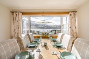 a dining room with a table and chairs and a large window at 3 Bed in Lochearnhead oc-c33641 in Lochearnhead