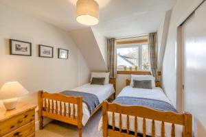 two twin beds in a room with a window at 3 Bed in Lochearnhead oc-c33641 in Lochearnhead