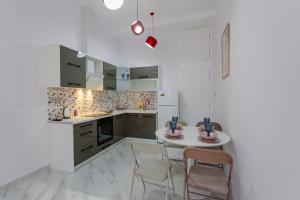 a white kitchen with a table and chairs at EVE's house 6 - Corinth center loft in Korinthos