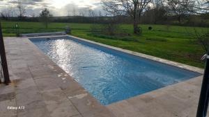 a swimming pool with blue water in a yard at Lieu-dit Plaisance in Puygouzon-et-Montsalvy