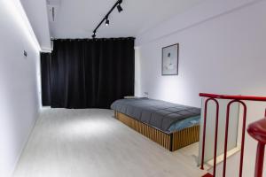a bedroom with a bed and a black curtain at EVE's house 6 - Corinth center loft in Korinthos