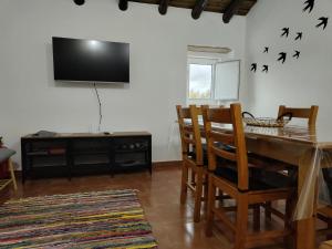 a dining room with a table and chairs and a television at Refúgio de Monsaraz in Monsaraz