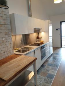 a kitchen with white cabinets and a wooden table at Ajaccio Sanguinaires in Ajaccio