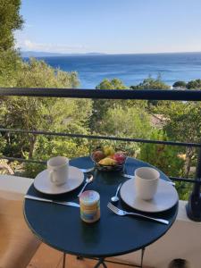 a table with two cups and a bowl of fruit on a balcony at Ajaccio Sanguinaires in Ajaccio