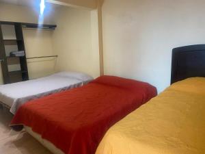 a bedroom with two beds with red and white sheets at La Casita Azul in Orizaba +38 photos