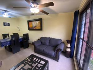 a living room with a couch and a ceiling fan at La Casita Azul in Orizaba