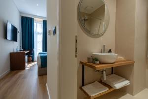 a bathroom with a sink and a mirror on the wall at Golden City Boutique Hotel Tirana in Tirana +100 photos