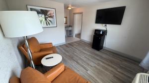 a living room with a couch and a flat screen tv at Harmony Inn and Suites in Beaumont +12 photos