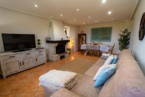a living room with a couch and a flat screen tv at El Caracol azul del Plano in Siero