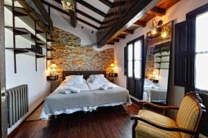 a bedroom with a bed and a stone wall at Casa La Palomba in Cudillero