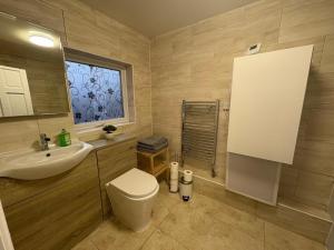 a bathroom with a toilet and a sink and a window at 2 Bed Flat - Sleeps 3 - Parking - Wifi in West Boldon