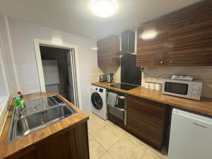 a kitchen with a sink and a microwave at 2 Bed Flat - Sleeps 3 - Parking - Wifi in West Boldon