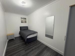 a small room with a bed and a mirror at 2 Bed Flat - Sleeps 3 - Parking - Wifi in West Boldon