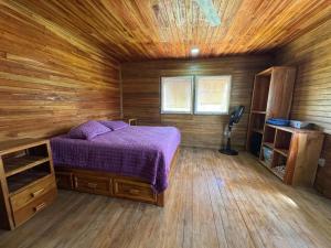 a bedroom with a bed in a wooden cabin at Cabaña Olas del Viento 1 in San Bernardo del Viento