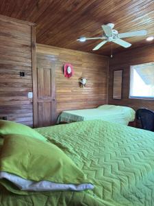 a bedroom with two beds and a ceiling fan at Cabaña Olas del Viento 1 in San Bernardo del Viento