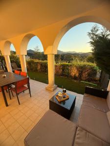 a patio with a couch and a table with a view at French Riviera Golf in Mandelieu-La Napoule