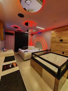 a room with a tub and a room with red lights at Fashion Motel in Limeira +27 photos