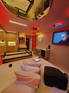 a room with three beds and a flat screen tv at Fashion Motel in Limeira