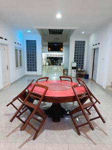 a dining room with a table and four chairs at Mutiara Guest House Syariah in Padangluar