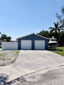 a garage with two white garage doors and a boat at 2 bed peaceful, lakeview studio NO FEES in Atlantis