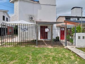 a fence in front of a white building at Elba Cabañas in Villa Carlos Paz