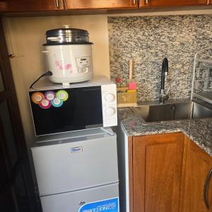a microwave on top of a refrigerator in a kitchen at Sweetland Vesidences in Yaoundé +5 photos