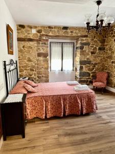 a bedroom with a bed and a stone wall at Casa La Ería in Sevares