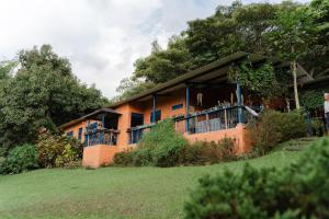 an orange house with a balcony on a hill at Finca Romelia Orchids and Birds in Manizales
