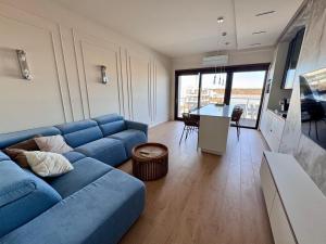 a living room with a blue couch and a table at Aqua Concept Apartment Sol Marina in Wiślinka