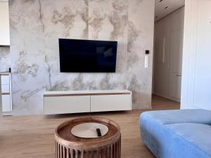 a living room with a tv on a wall at Aqua Concept Apartment Sol Marina in Wiślinka