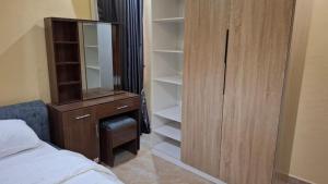 a bedroom with a dresser and a closet with a mirror at Cherished Homes in Ikeja