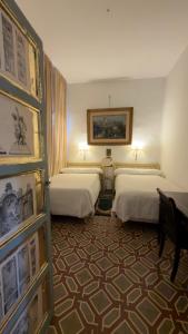 a hotel room with two beds and a painting on the wall at Apartamento Biembe in Chinchón