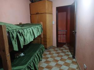 a room with a bed with a green sheet on it at Elba Cabañas in Villa Carlos Paz