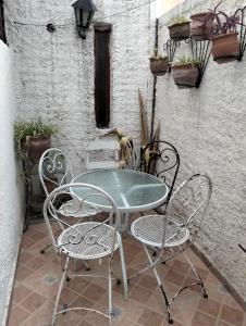a glass table and chairs on a patio at Elba Cabañas in Villa Carlos Paz