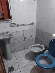 a bathroom with a toilet and a sink at Elba Cabañas in Villa Carlos Paz
