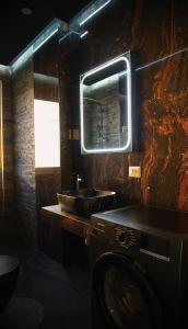 a bathroom with a sink and a washing machine at Central Residence Sky Apartment in Rădăuţi