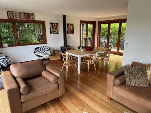 a living room with a couch and a table at Little Palm Beach Hideaway in Waiheke Island