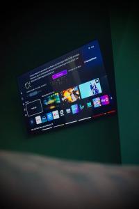 a television screen on a green wall with areens at Central Residence Sky Apartment in Rădăuţi