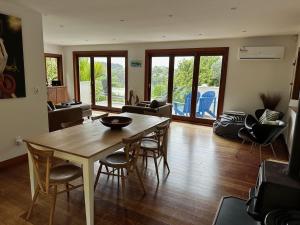 a living room with a wooden table and chairs at Little Palm Beach Hideaway in Waiheke Island +15 photos