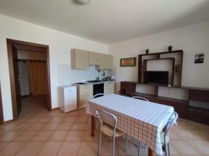 a kitchen with a table and chairs and a kitchen with a counter at Ca Gabbiano 6 in Santa Maria