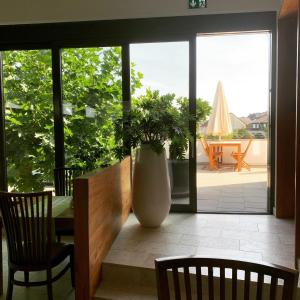 a dining room with a table and a vase with a plant at Hotel Nassauer Hof in Kiedrich