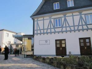 a man standing in front of a white and black building at Hotel Nassauer Hof in Kiedrich