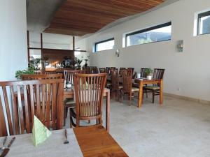 a dining room with wooden chairs and tables and windows at Hotel Nassauer Hof in Kiedrich