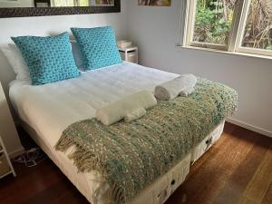 a bedroom with a bed with towels on it at Little Palm Beach Hideaway in Waiheke Island